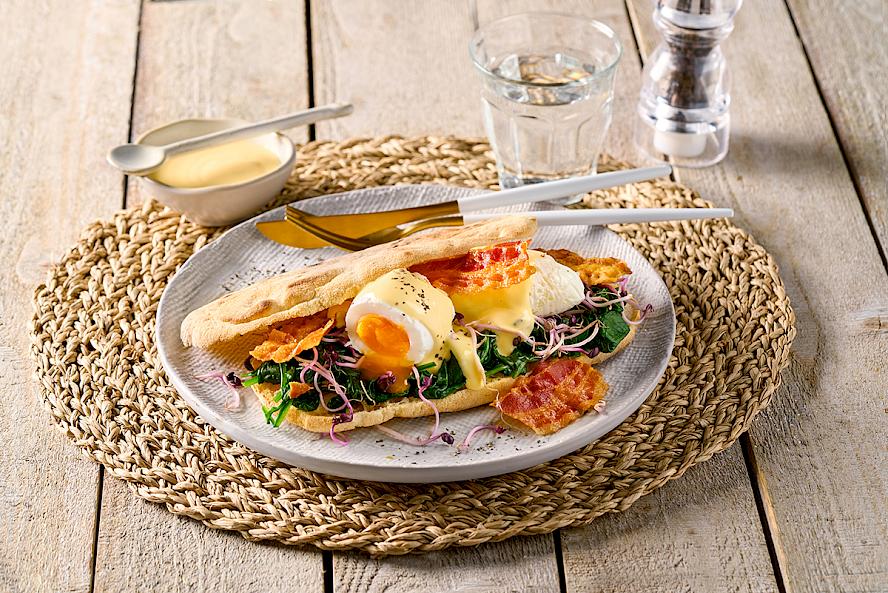 Rezeptidee: Pane di Napoli bestrichen mit Hollandaisesauce, belegt mit Spinat, pochiertem Ei und garniert mit Knusperspeck und Sprossen